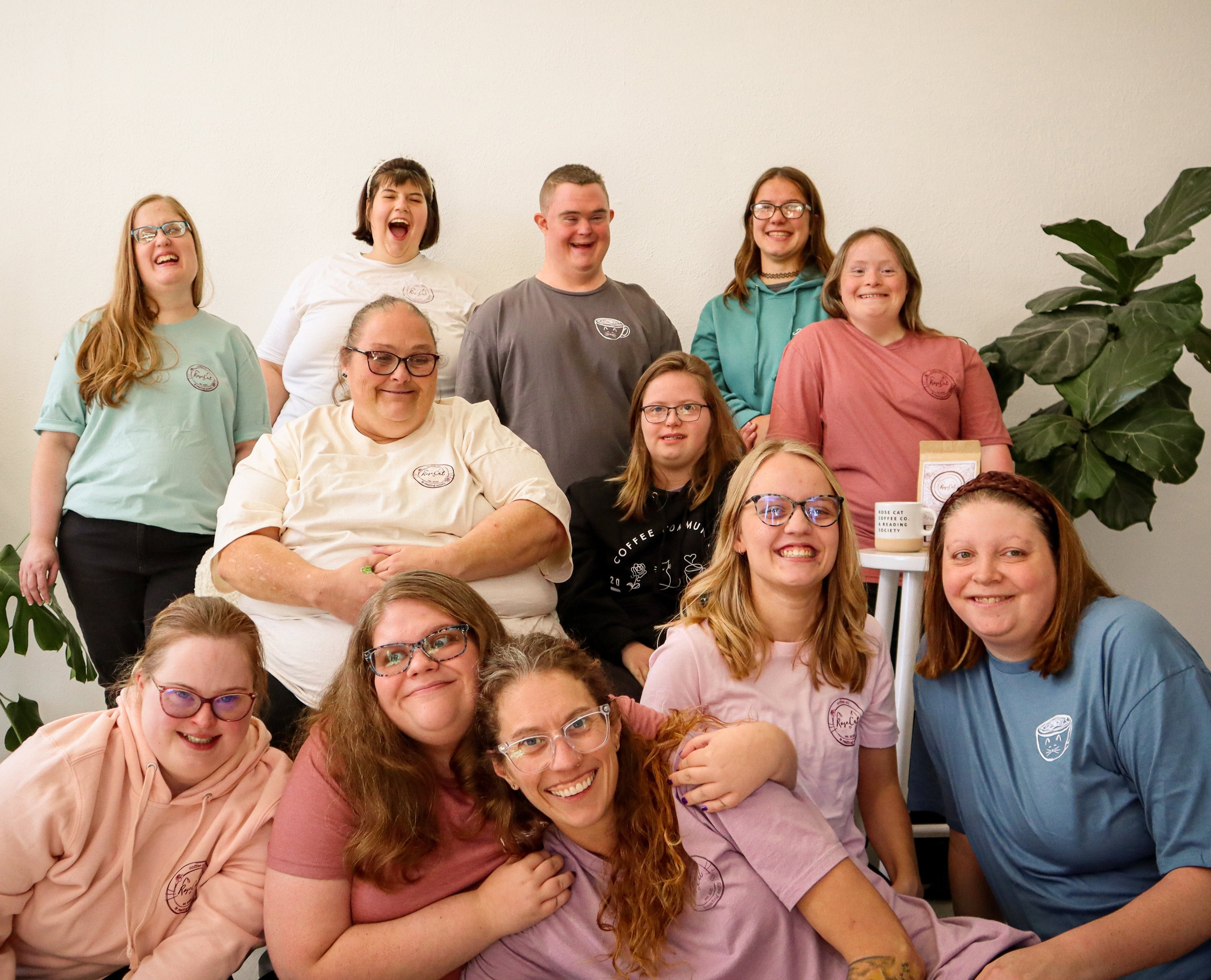 Rose Cat Coffee Co employees pose with Owner Brenda Kasaty while wearing merchandise, available in store or online.